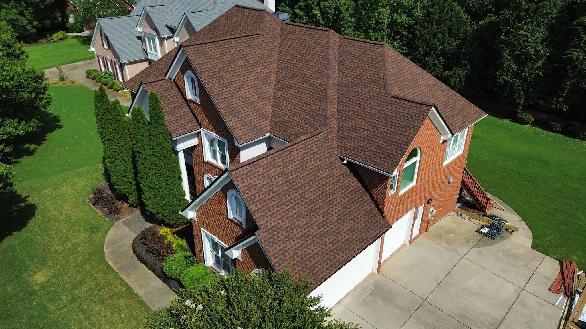 Brown shingle roof across multiple roof planes on a brick house